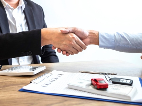 Men Shaking Hands with a Car Rental Contract