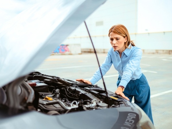 Woman Looking at a Broken Car